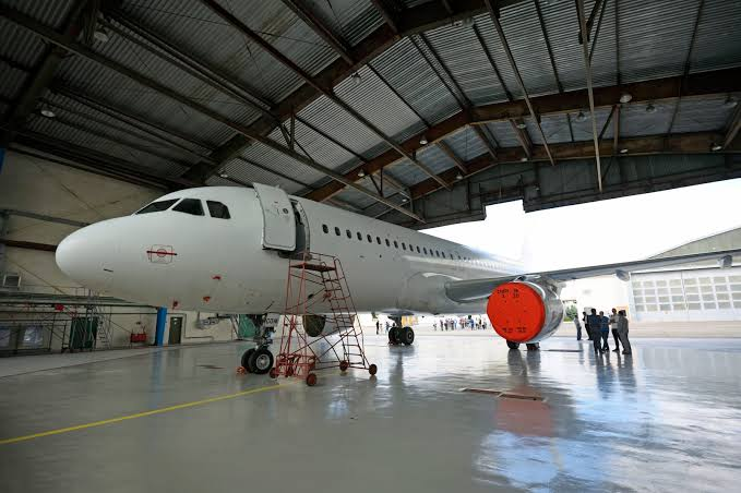 Aeronave en hangar con personal técnico realizando inspección